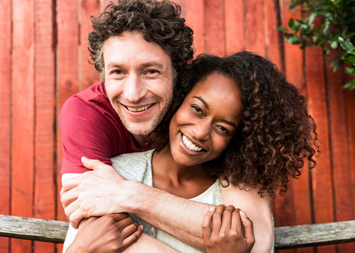 A happy couple smiles together knowing they have achieved financial wellness