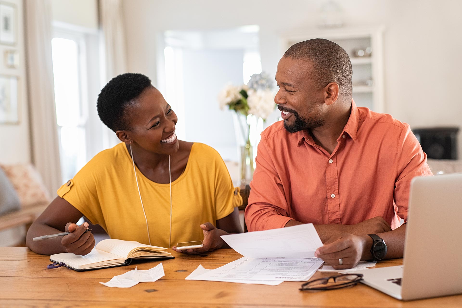 Couple reviewing paperwork and planning how to consolidate their debt by refinancing.