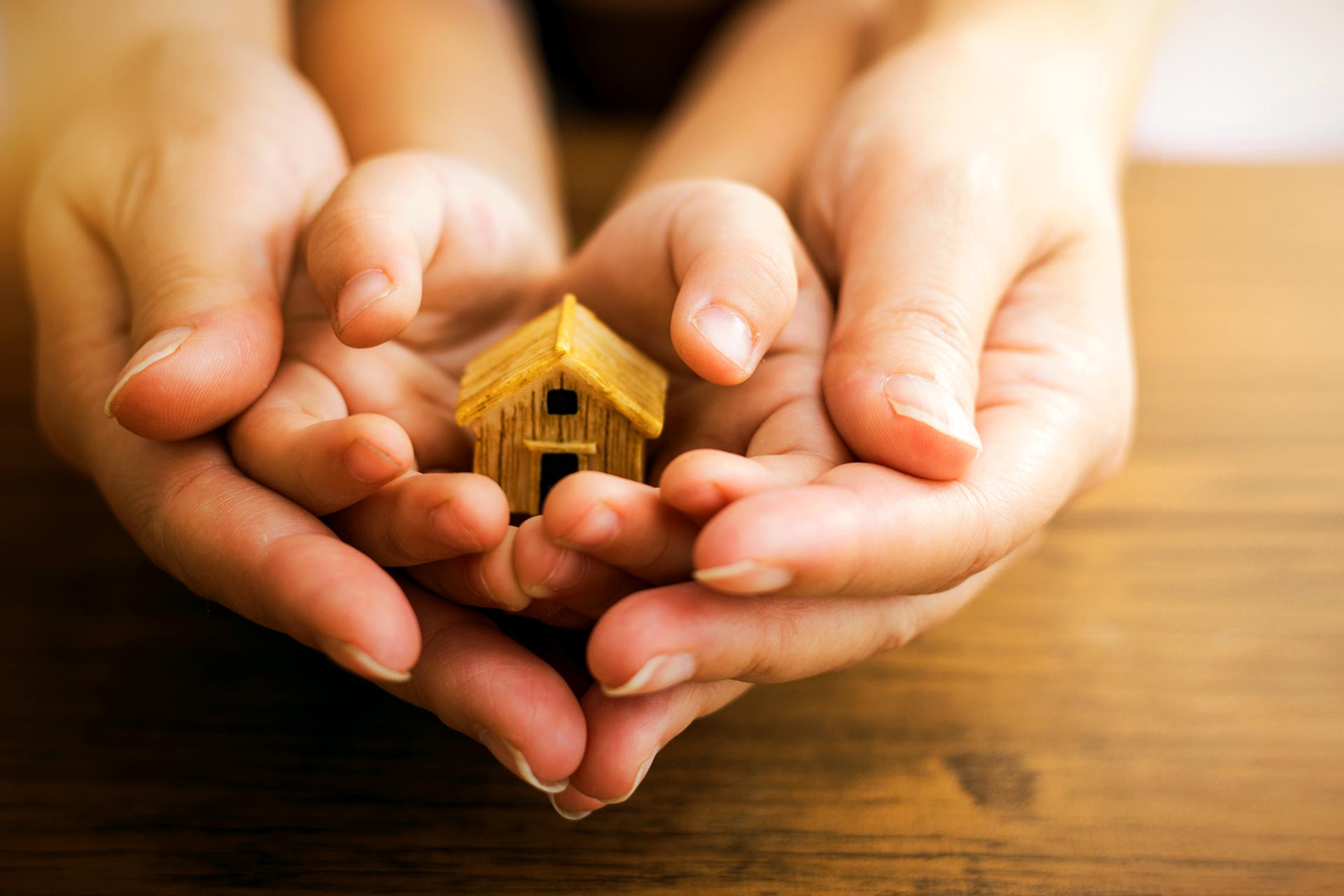 Mother and son hold a toy house.